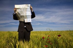 Homme d'affaires lisant une carte dans un champ